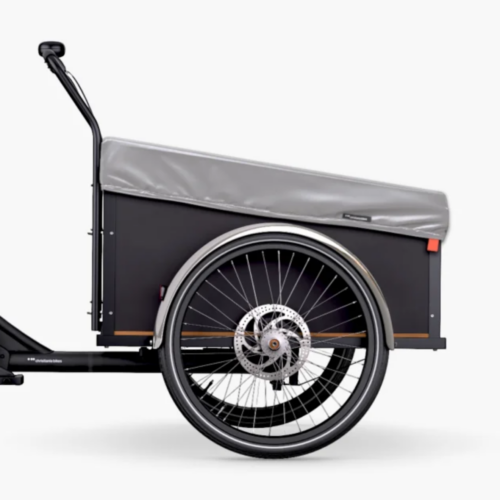 Sidovy av en lastcykel med ett stort främre lastutrymme som skyddas av Christiania Bikes Regnskydd för låda – Silver, med svart ram, stort ekershjul och skivbroms, mot en vit bakgrund. Utrustningen inkluderar Christiania Bikes Y-bälte för ökad stabilitet och säkerhet.