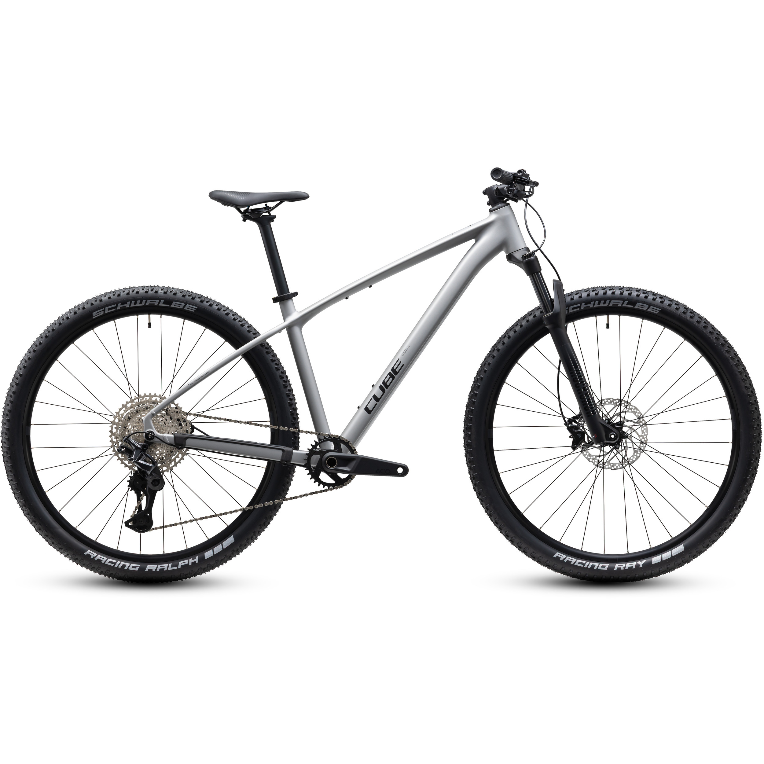 Cube 1141200 En silverfärgad mountainbike med rakt överrör, platt styre, framgaffel med fjädring och stora knubbiga däck. Cykeln avbildas från sidan mot en enfärgad vit bakgrund.