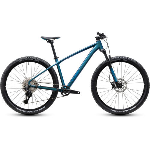 En blå MTB 27,5 Cube Reaction PRO hardtail-mountainbike med Shimano XT 1x12-drivlina, rakt styre, framgaffel med fjädring, svart sadel, 27,5-tums hjul och skivbromsar. Drivlinan och däcken syns tydligt, och cykeln visas mot en vit bakgrund.