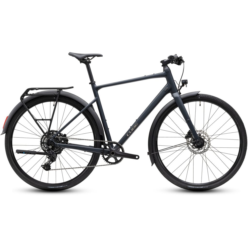 Matt svart hybridcykel med rakt styre, skivbromsar, bakre pakethållare och helskärmar. Cykeln är fotograferad från sidan, vilket visar dess moderna ramkonstruktion och smala däck som passar bra för pendling i staden.