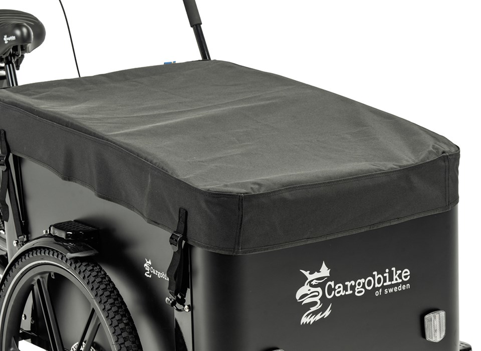 Regnskydd Cargobike Delight:Flex Erlan 3 En svart lastcykel med ett täckt lastutrymme, utrustad med Cargobike regnskydd för Delight och Flex Nova – Svart (för låda) för extra skydd. Det monterade svarta skyddet pryds av ”Scargobike of Sweden”-logotypen i vitt tillsammans med en illustration av ett griffhuvud på sidan av lastutrymmet.